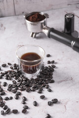 Sticker - Vertical shot of black coffee, coffee beans, and portafilter on a marble surface