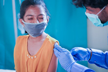Concept Of Covid-19 Coronavirus Vaccination For Children - Young Girl Kid Getting Jab Or Vaccinated To Against Covid At Hospital