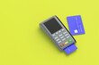 © OlekStock - Portable cash register with plastic credit card on yellow background. Copy space. 3d render