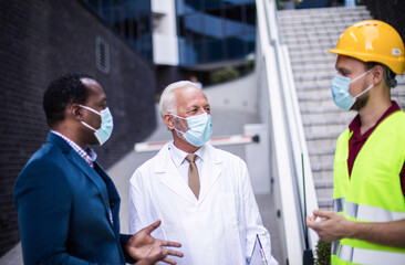 Wall Mural - Business man, doctor and engineer talking on street.