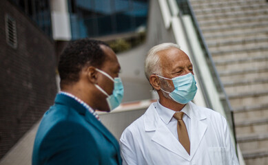 Wall Mural - Business man, and doctor on street. Focus on senior man.