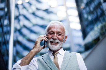 Wall Mural - Senior business man talking on smart phone.