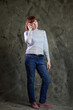 © Вячеслав Чичаев - Portrait of cute Caucasian woman posing in full growth in jeans in studio on gray background. High resolution photos