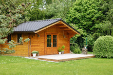 Wooden Hut In Spring. Garden Shed For Vacation. Nice Garden In Germany. Well-kept Garden With Freshly Cut Green Grass And Potted Plants 