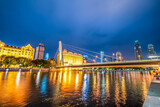 Fototapeta Mosty linowy / wiszący - Night view of modern architecture street along Haihe River in Tianjin