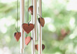Close up image of wooden hearts hanging with wind chime