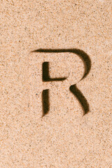 Letter R of the sand isolated on the beach sand. concept of summer. alphabet.