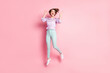 © deagreez - Full length photo portrait of excited girl jumping up isolated on pastel pink colored background
