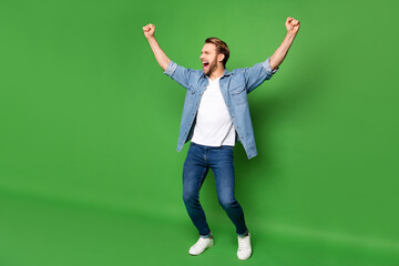 Wall Mural - Full length body size photo of overjoyed man gesturing like winner in stylish clothes isolated bright green color background