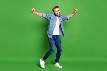 Sticker - Full length body size photo of happy guy cheerful dancing at party isolated vibrant green color background