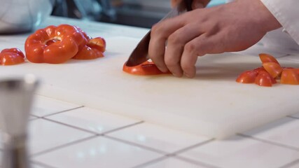 Wall Mural - The chef cutting bell pepper using sharp knife on a chopping board.