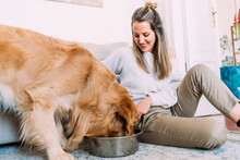 Young woman feeding dog