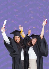 Wall Mural - Composition of two happy diverse female students with certificates in graduation hats on purple