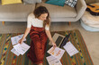 © Wavebreak Media - Caucasian woman working at home sitting on floor with paperwork and laptop