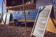© Wavebreak Media - General view of food truck and menu board by seaside on sunny day