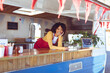 © Wavebreak Media - Portrait of smiling mixed race woman leaning on counter in food truck