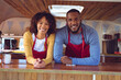 © Wavebreak Media - Portrait of smiling diverse couple behind counter in food truck