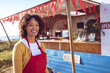 © Wavebreak Media - Portrait of smiling mixed race woman standing by food truck on sunny day