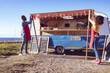 © Wavebreak Media - Diverse couple opening and preparing food truck by seaside on sunny day
