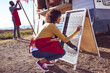 © Wavebreak Media - Diverse couple opening and preparing food truck by seaside on sunny day, woman writing on menu board