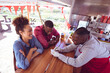 © Wavebreak Media - Smiling african american man in food truck chatting to male and female customers
