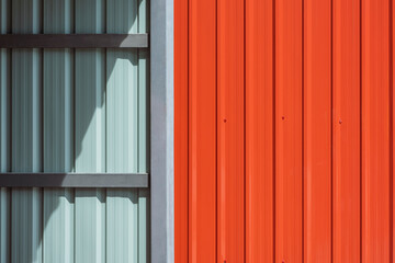 Wall Mural - Sunlight and shadow on steel wall surface of storage room or garage with orange metal sheet fence wall outside of home, construction material concept