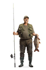 Poster - Full length portrait of a happy fisherman in a uniform holding a big carp fish and a fishing rod