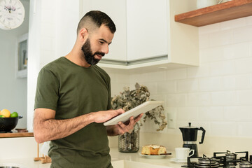 Wall Mural - male fingers amputee using tablet and having breakfast at kitchen.