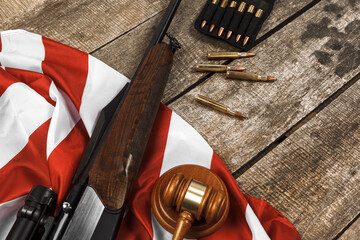 Wall Mural - Wooden judge gavel and hunting rifle over USA flag on wooden background