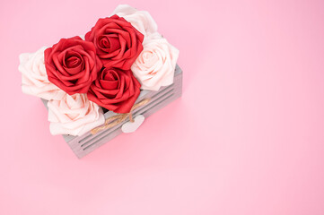 Poster - Red and white roses in a box isolated on a pink background