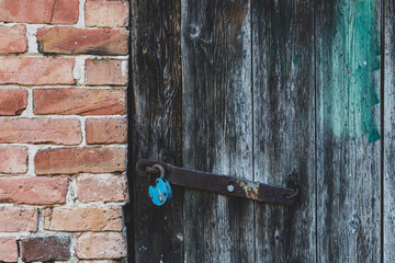 Wall Mural - A wooden door in an old brick wall. Detail of an abandoned building