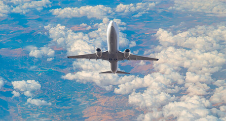 White passenger airplane over the clouds  - Travel by air transport