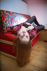 Poster - Vertical shot of a white Caucasian woman posing for a picture on the sofa