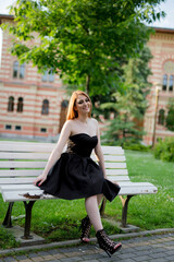 Wall Mural - Vertical shot of a white Caucasian woman wearing a classy black dress and posing for a picture