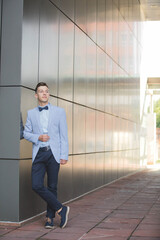 Sticker - Vertical shot of a young male model posing in a light blue suit and a bow tie