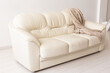 © satura_ - Beige sofa in room on white background. Simple minimalistic design.