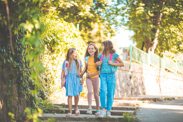 Wall Mural - Three little girls going to school.