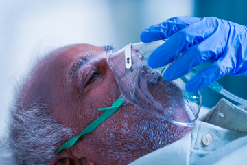 close up shot, doctor helping by adjusting ventilation oxygen mask to covid infected difficulty in b