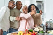 © Alessandro Biascioli - Happy Latin family having fun taking selfie with mobile smartphone while preparing healthy lunch in modern kitchen at home - Food and parents unity concept