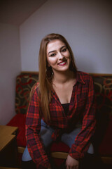 Poster - Vertical shot of a white Caucasian woman posing for a picture on a blurred background