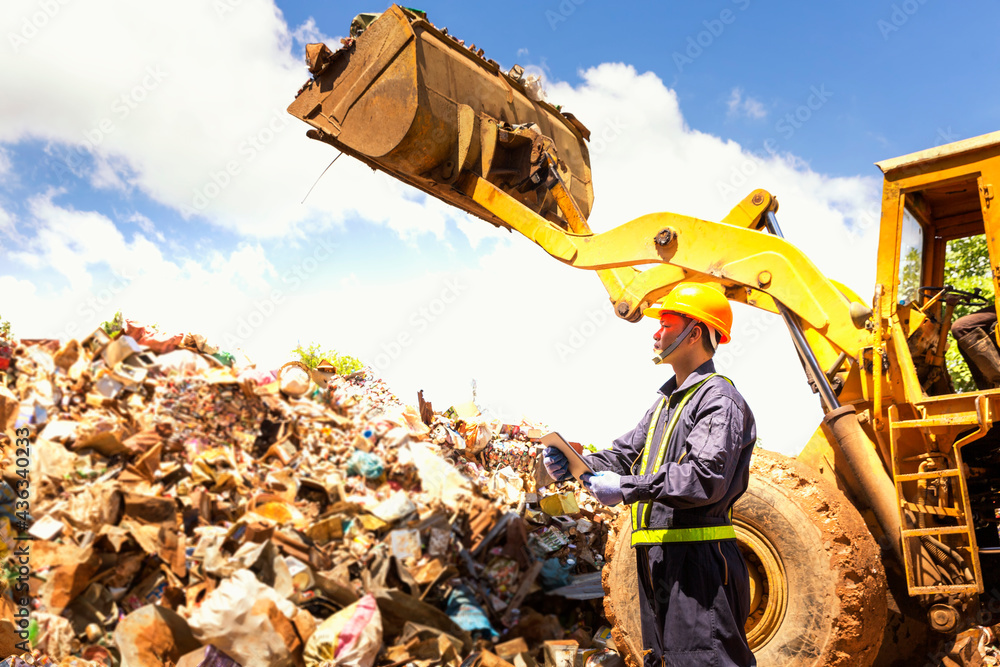 Waste Rehandler Engineer driving a loader in the recycling plant. Factory recycle ...