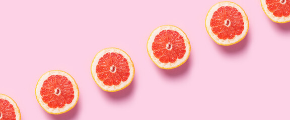 Wall Mural - Half grapefruit on a pink background. Pattern. Banner. Flat lay, top view