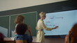 © stockbusters - Teacher using interactive digital whiteboard. Student writing on smart board