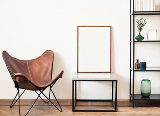 Blank picture frame mockup in interior design. Living room, chair with bookcase. View of modern rustic style interior with artwork template on a white wall. Home design concept