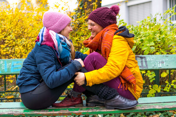 Poster - Young lesbian couple sitting close and looking at each other on an old green be