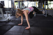 © Ihor - Young woman exercising at gym, using trx system trainer
