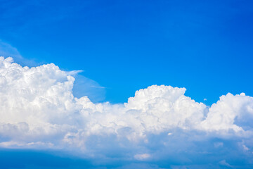 Wall Mural - Beautiful white clouds in a bright blue sky on a warm summer day