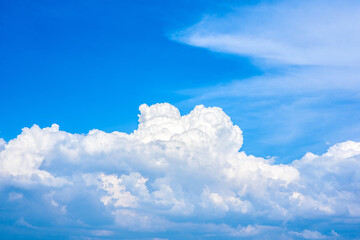 Wall Mural - Beautiful white clouds in a bright blue sky on a warm summer day