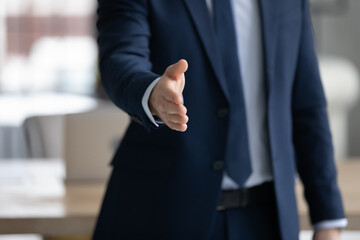 Sticker - Businessman in formal suit offering handshake. Business leader giving hand for shake. Recruiter inviting for job interview and hiring. Manager offering consultation to client or customer. Close up