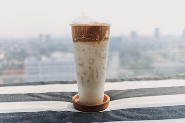 Iced coffee milk served in a tall plastic cup.